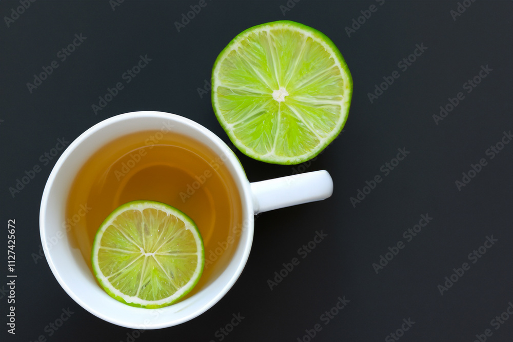 Glass tea and lime slice. Black background with tea and lime. Glass of tea with a slice of lime on the background. A glass of tea with a slice of lime on a lifestyle black background. Glass tea and lime slice. Black background with tea and lime. Glass of tea with a slice of lime on the background. A glass of tea with a slice of lime on a lifestyle black background.