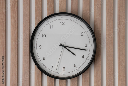 Wallpaper Mural A wall clock with a black frame and white face hangs prominently on a wooden striped wall, indicating the current time clearly Torontodigital.ca