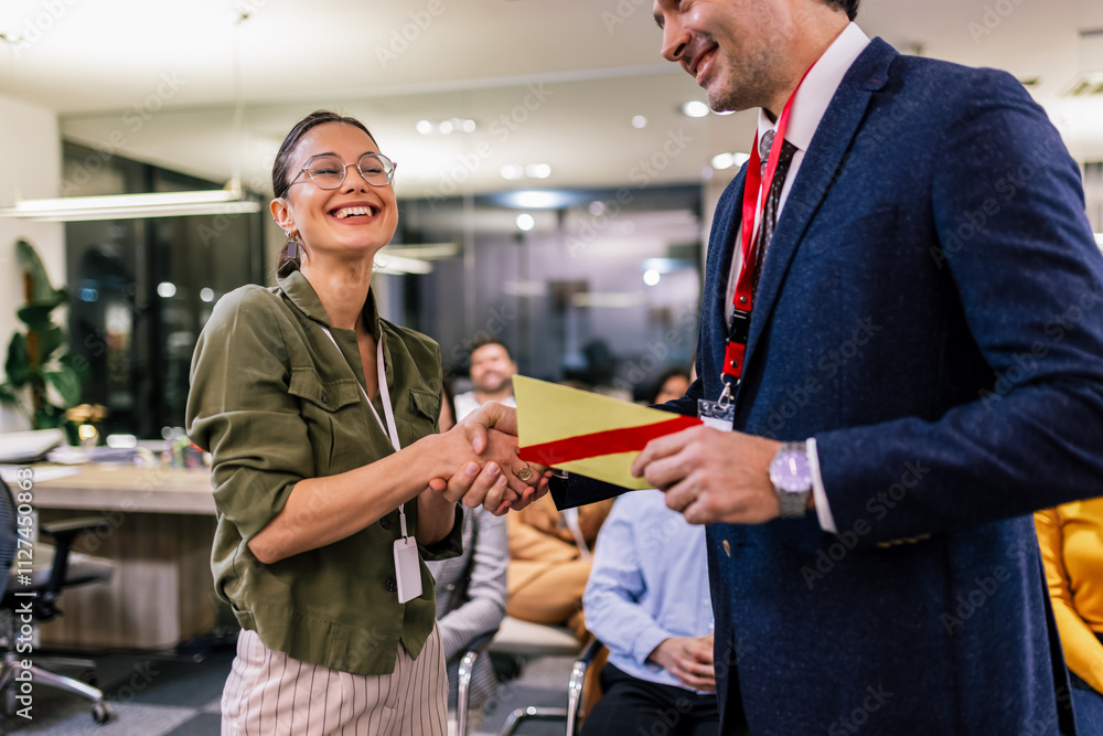 Obraz premium Front view of businesswoman receiving award from businessman in front of business professionals applauding at business seminar in office building