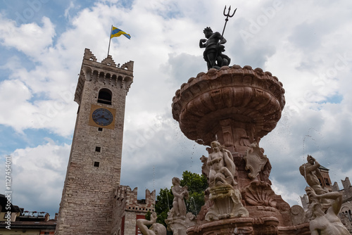 Fountain with statue of Neptune on historic square Piazza Duomo in city of Trento, Trentino Alto Adige, Italy. Torre del Campanone  stands in background. Travel destination and tourist attraction photo