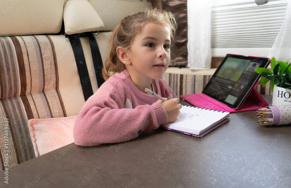 a girl looks at her mother while she draws in her motorhome a girl looks at her mother while she draws in her motorhome