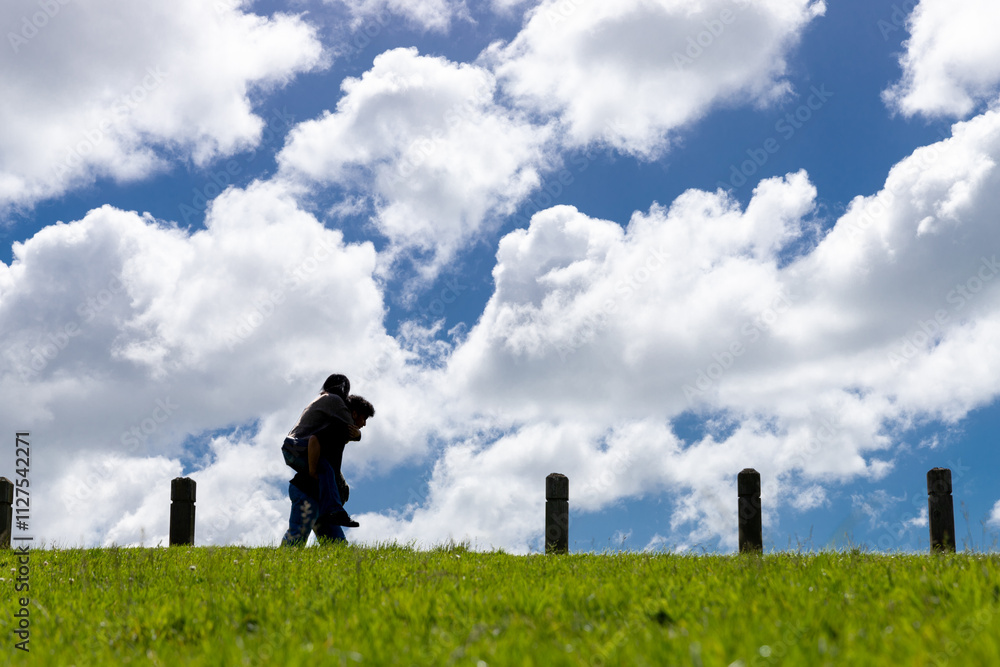 Young couple having fun with clouds in the background Young couple having fun with clouds in the background