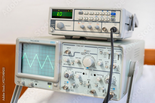 Green sine waves on the screen of a multi-button oscilloscope photo