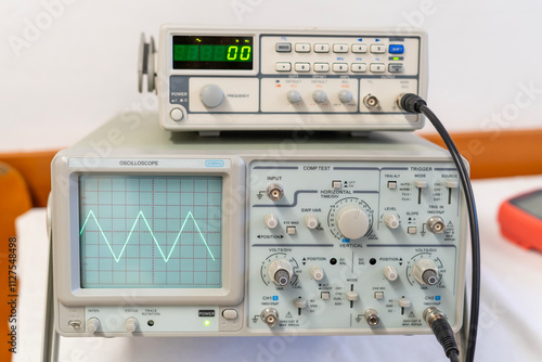 Green sine waves on the screen of a multi-button oscilloscope photo