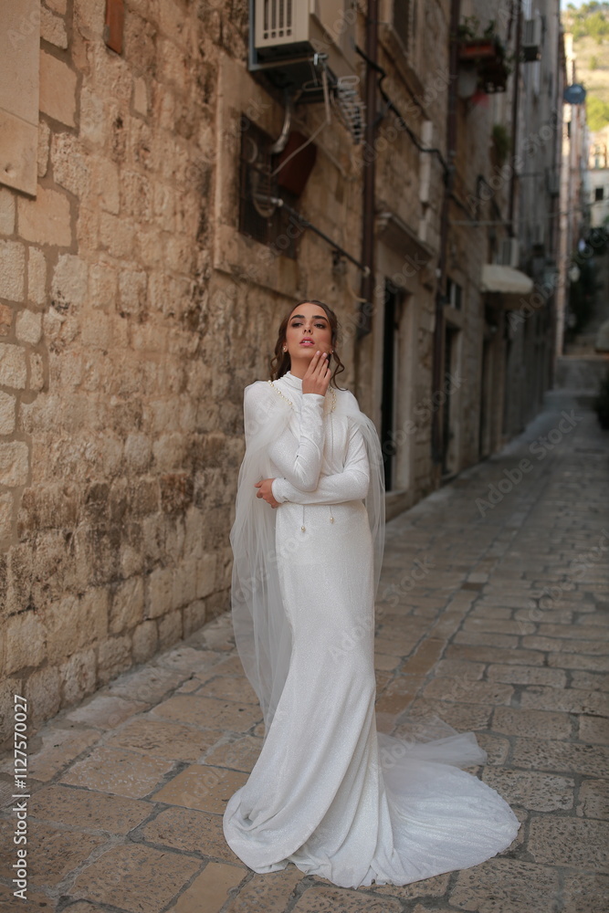 beautiful bride dressed in a white dress stands in the middle of the old town. wedding photoshoot in the old town of Croatia. old medieval castle beautiful bride dressed in a white dress stands in the middle of the old town. wedding photoshoot in the old town of Croatia. old medieval castle