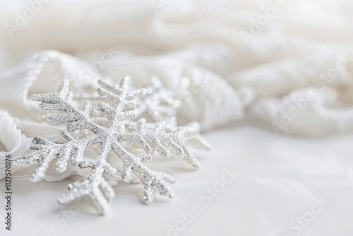 Sparkling silver snowflake decoration on white soft fabric for winter and holiday ambiance