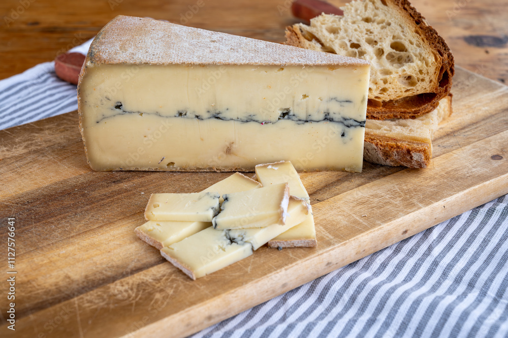 Cheese collection, French Morbier semi-soft cow milk cheese with black mold layer close up Cheese collection, French Morbier semi-soft cow milk cheese with black mold layer close up