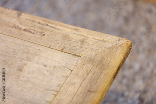 Close-up of a weathered, light brown wooden corner.  Natural wood grain and texture are visible. photo