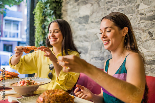 Latinx female friends together eating happy in a Ecuadorian food restaurant. Traditional meal photo