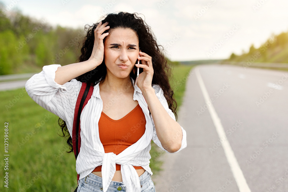 Confused young woman standing along road, feeling lost, calling on smartphone, checking travel options outdoors, copy space. Stressed millennial lady cannot catch ride, hitchhiking alone on highway Confused young woman standing along road, feeling lost, calling on smartphone, checking travel options outdoors, copy space. Stressed millennial lady cannot catch ride, hitchhiking alone on highway