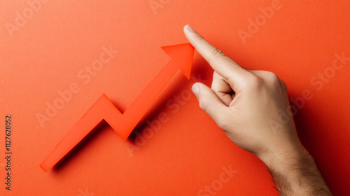 Male hand is pointing at a rising red arrow symbolizing business growth, success and positive financial results