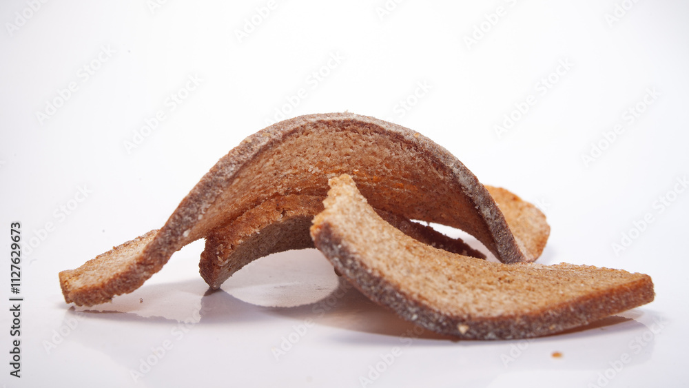 Unique arrangement of crispy bread pieces on a plain background showcasing texture and color Unique arrangement of crispy bread pieces on a plain background showcasing texture and color