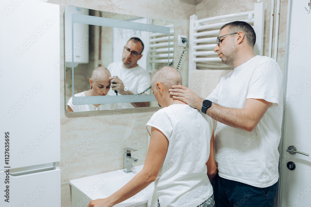 Obraz premium A caring individual is attentively shaving the head of another in a modern bathroom setting, showcasing the profound connection and emotional support shared between them in this intimate moment.