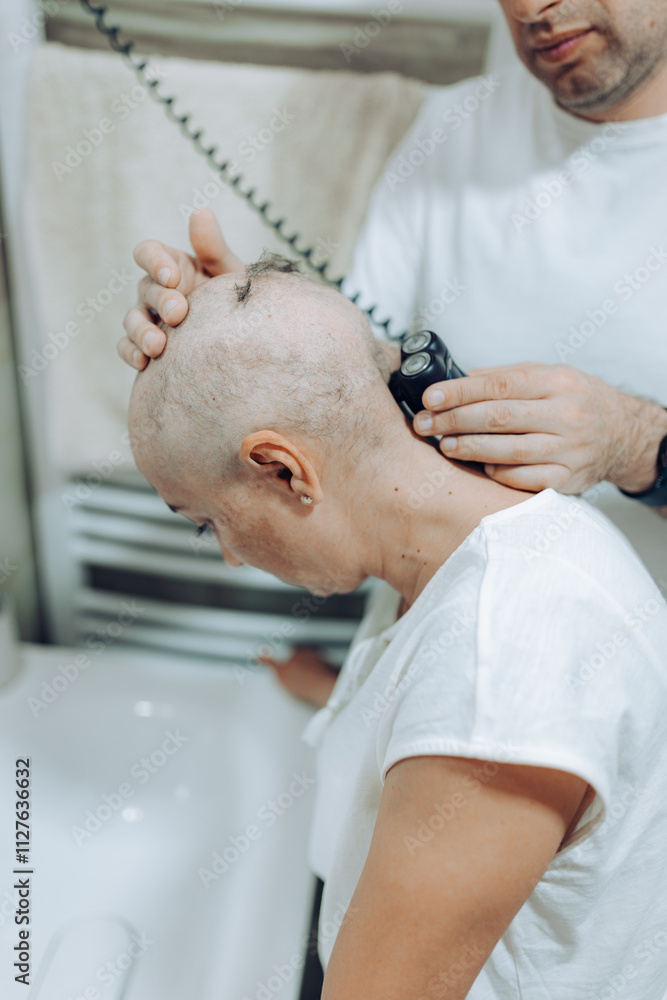 Obraz premium Woman with cancer. This close-up captures the act of shaving in a bathroom, depicting the care involved as one person helps another achieve a bald look with attention and focus.