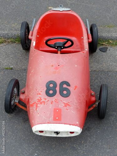 Altes Tretauto für Kinder in Rot iim Design eines Rennwagen der Fünfzigerjahre auf dem Trödelmarkt und Flohmarkt beim Oldtimertreffen Golden Oldies in Wettenberg Krofdorf-Gleiberg bei Gießen in Hessen photo