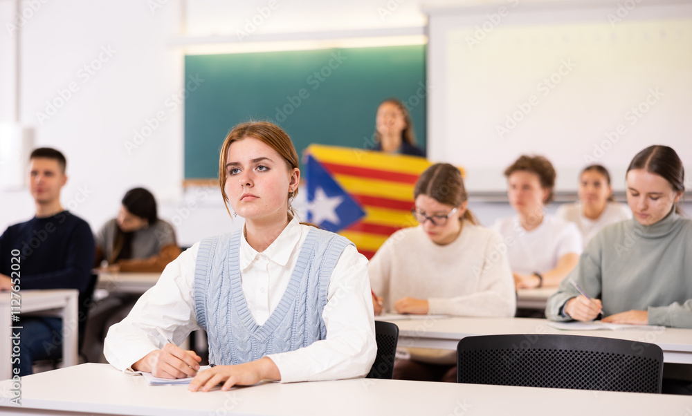 © JackF - Students study in classroom, teacher stands behind with flag of Catalonia