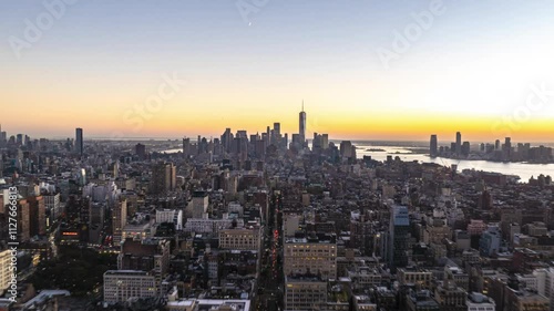 Aerial hyperlapse over Manhattan, Lower East Side, Financial District and One World Trade Center in New York City. Moon stands in the sky as day turns to night
