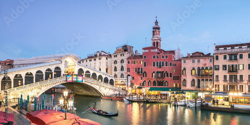 Rialto bridge at dusk with gondola on the grand canal, Venice, Italy