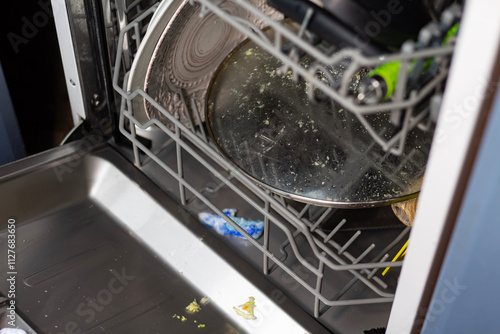 The dishwasher is loaded with dishes, a shot with a detergent tablet.