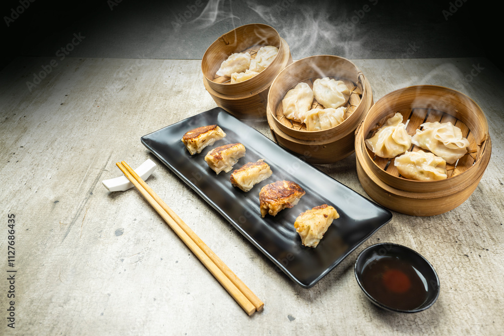 Fried chinese dim sum dumpling, gyoza, jiaozi or mandu in the plate with chopsticks and soy sauce on the table. Food for breakfast, lunch or dinner Fried chinese dim sum dumpling, gyoza, jiaozi or mandu in the plate with chopsticks and soy sauce on the table. Food for breakfast, lunch or dinner