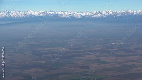 Top bird eye View from passenger porthole of beautiful landscape Flying airplane engine wing of plane fly on sunny cloudy day in winter. Transport, tourism, travel, flight, holidays vacation concept.