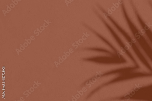 Shadow leaf dypsis on Mocha Mousse color wall. Mocha mousse color of the year 2025. Monochrome background.