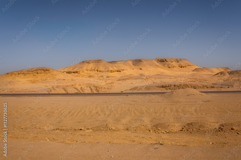 Desert landscape with sand dunes, blue sky and empty road. Desert landscape with sand dunes, blue sky and empty road.