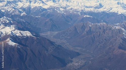 Top bird eye View from passenger porthole of beautiful landscape Flying airplane engine wing of plane fly on sunny cloudy day in winter. Transport, tourism, travel, flight, holidays vacation concept.
