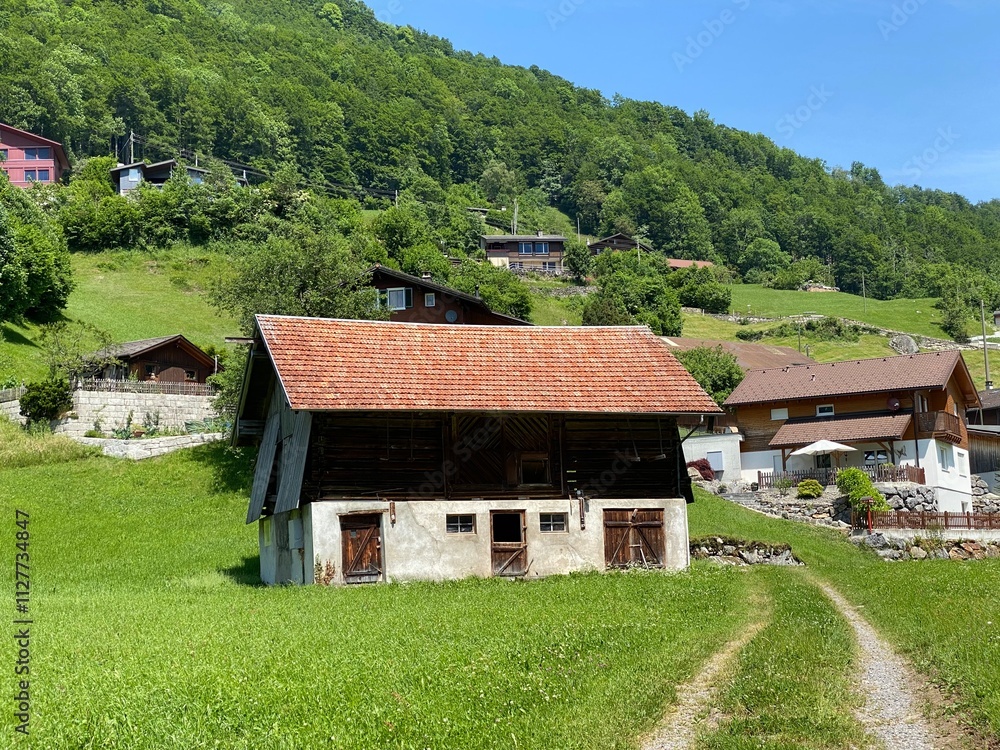Obraz premium Traditional rural architecture and family livestock farms on the shores of Lake Lungern - Canton of Obwald, Switzerland (Traditionelle Architektur am Ufer des Lungernsees - Schweiz)