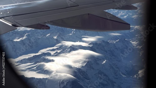 Top bird eye View from passenger porthole of beautiful landscape Flying airplane engine wing of plane fly on sunny cloudy day in winter. Transport, tourism, travel, flight, holidays vacation concept.