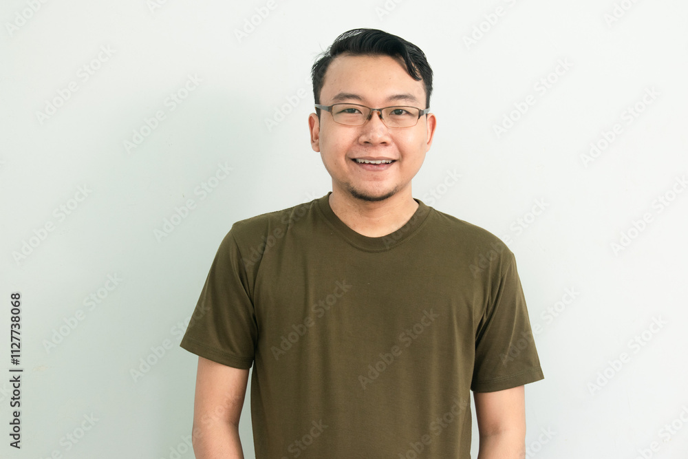 Obraz premium Confident asian man with green tshirt smile at camera. Isolated portrait.
