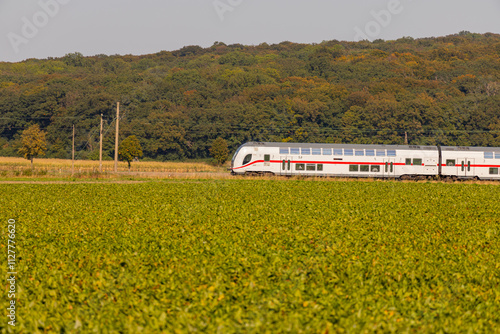 white double-decker people train across a field