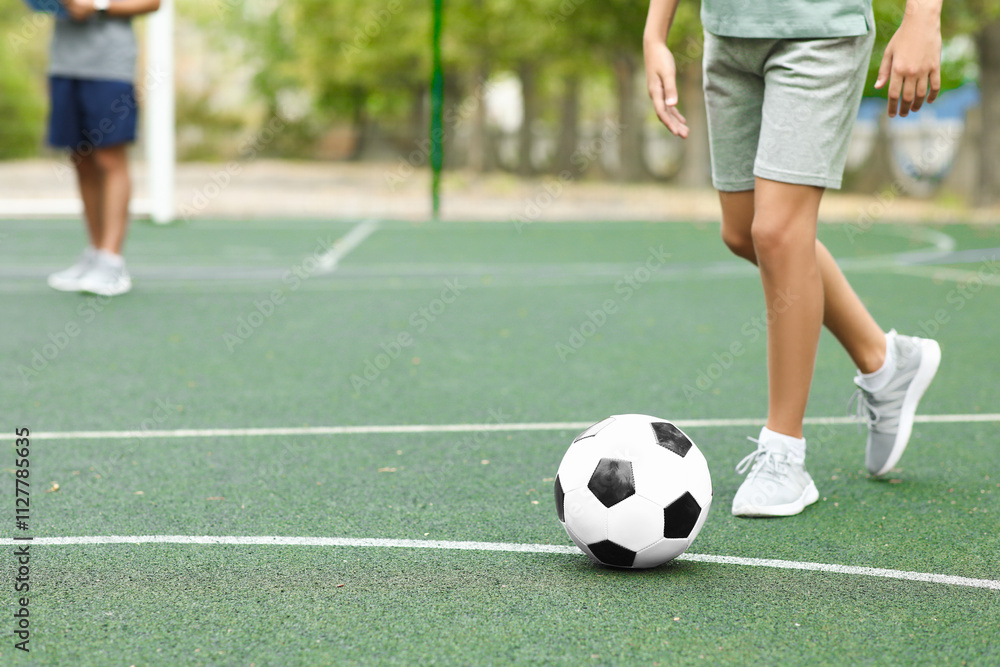 Happy boy with his dad playing football on soccer pitch Happy boy with his dad playing football on soccer pitch