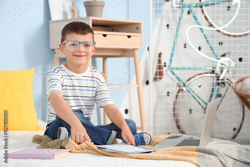 Cute little boy studying in...