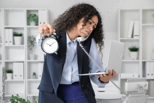 Work stress and deadline pressure, stressed businesswoman holding alarm clock...