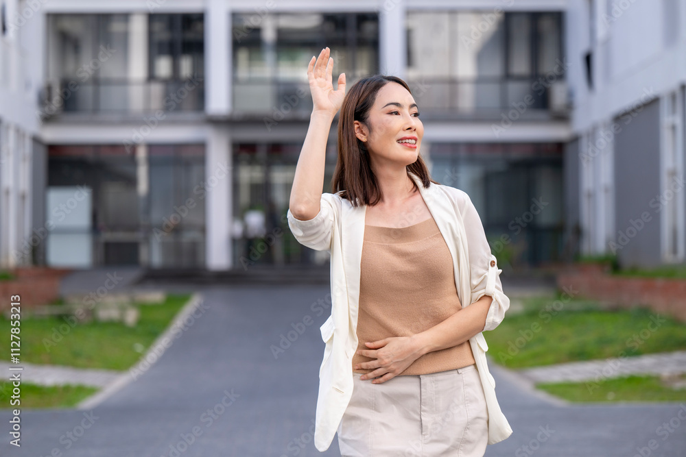 A woman in a white jacket and tan shirt is waving at the camera A woman in a white jacket and tan shirt is waving at the camera