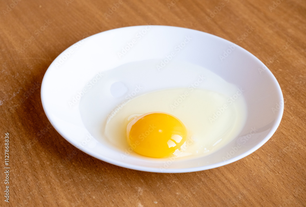 Raw egg in a plate. Egg yolk. Raw egg in a plate. Egg yolk.
