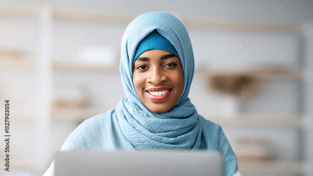 Closeup Portrait Of Black Islamic Freelancer Lady In Hijab Using Laptop And Smiling At Camera, Muslim African Woman Working Remotely On Computer At Home Office, Enjoying Distance Job, Free Space Closeup Portrait Of Black Islamic Freelancer Lady In Hijab Using Laptop And Smiling At Camera, Muslim African Woman Working Remotely On Computer At Home Office, Enjoying Distance Job, Free Space