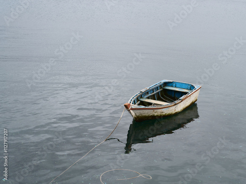 Small old wooden boat in calm water