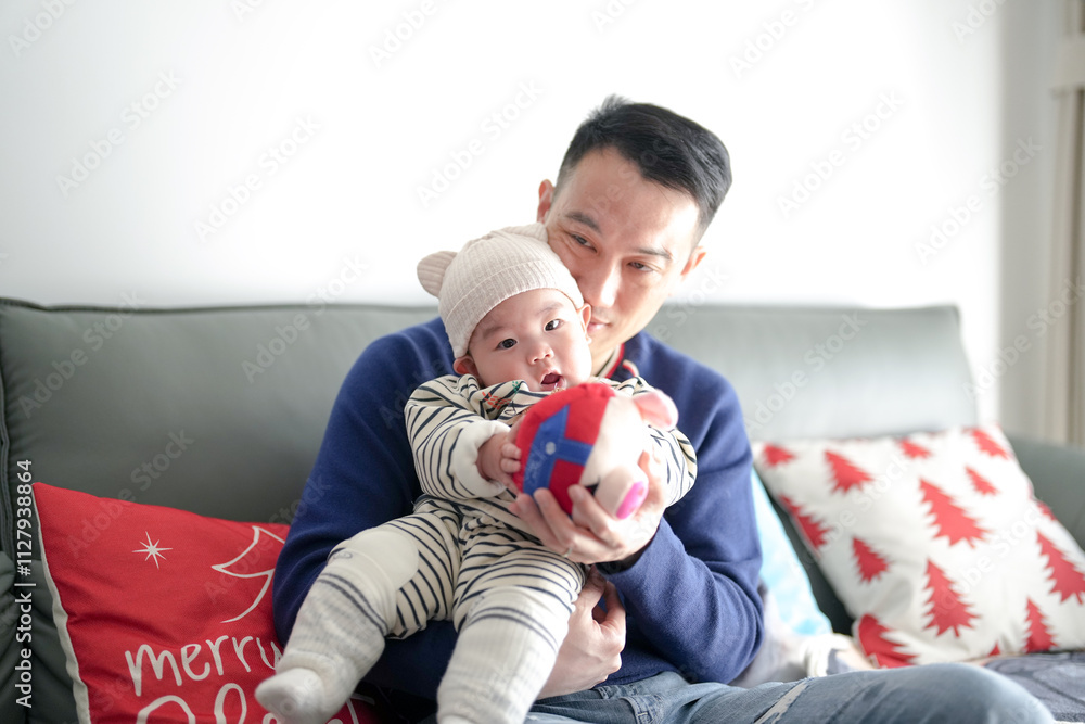 A six-month-old boy wearing Christmas clothes spends time indoors with his father from a Chinese family on a cold winter day in Pudong New Area, Shanghai, China. A six-month-old boy wearing Christmas clothes spends time indoors with his father from a Chinese family on a cold winter day in Pudong New Area, Shanghai, China.