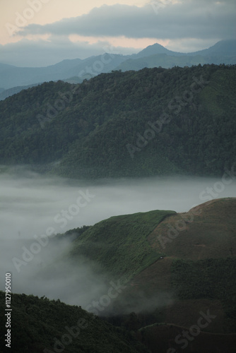 Panorama view layers of mountain with the fluffy white fog between the mountains and clear sky in background