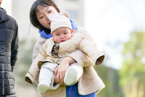 A 6-month-old boy plays with his mother and father, a Chinese family, on a cold winter day in a private garden in Pudong New Area, Shanghai, China. photo