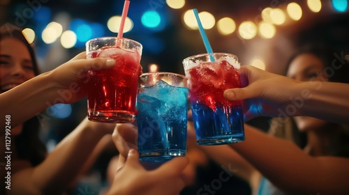 Four friends clinking glasses of red and blue cocktails at a party.