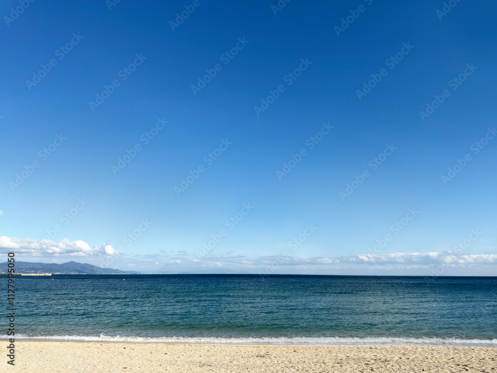透き通った青い空に一面に広がる海と砂浜 透き通った青い空に一面に広がる海と砂浜