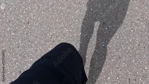 point of view of man foot running on asphalt road with shadow