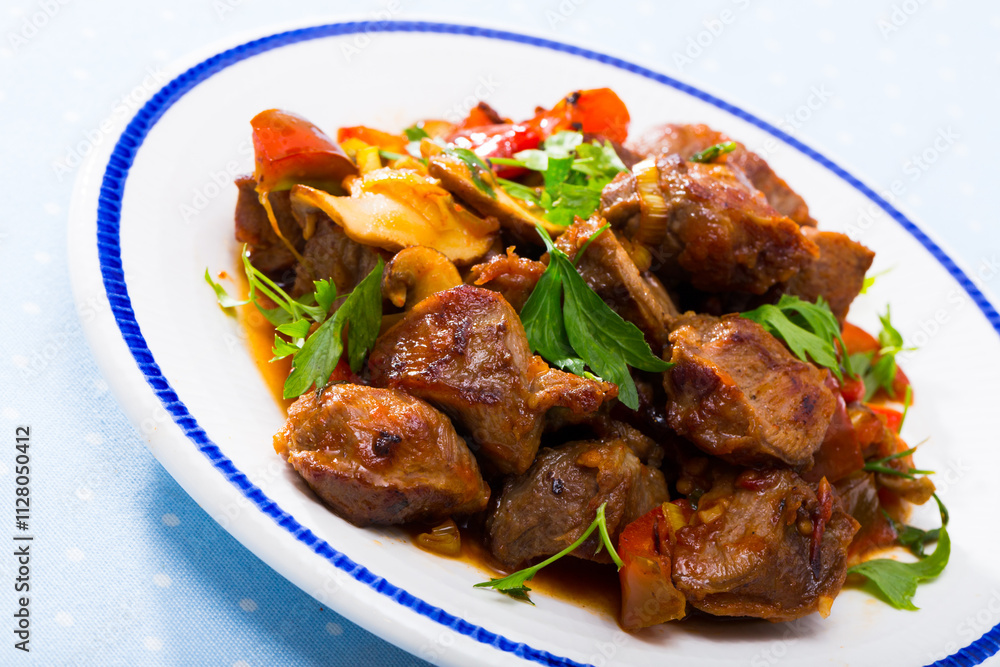 Close up of delicious fried pork with button mushroom, peppers and greens Close up of delicious fried pork with button mushroom, peppers and greens