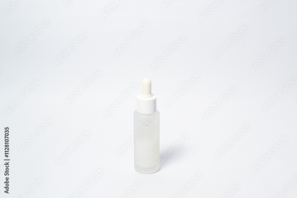 White dropper glass bottle with white liquid inside on isolated white background White dropper glass bottle with white liquid inside on isolated white background
