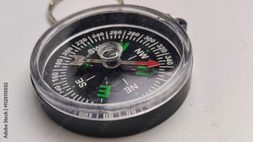 mini compass needle pointing to north on isolated white background mini compass needle pointing to north on isolated white background
