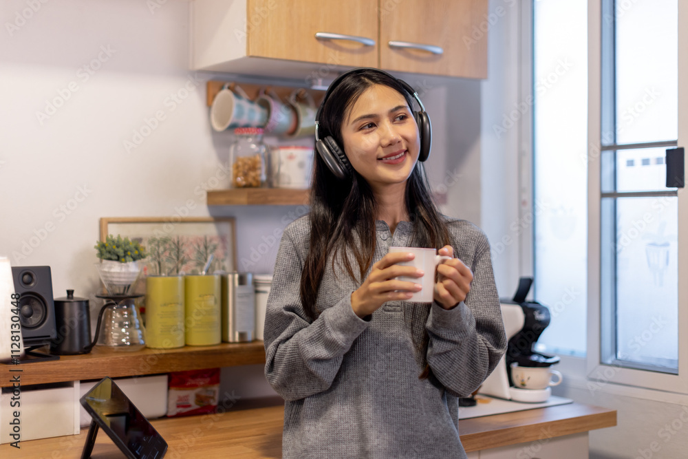 Asian student wearing headphones and drink coffee at in the kitchen
Asian student wearing headphones and drink coffee at in the kitchen