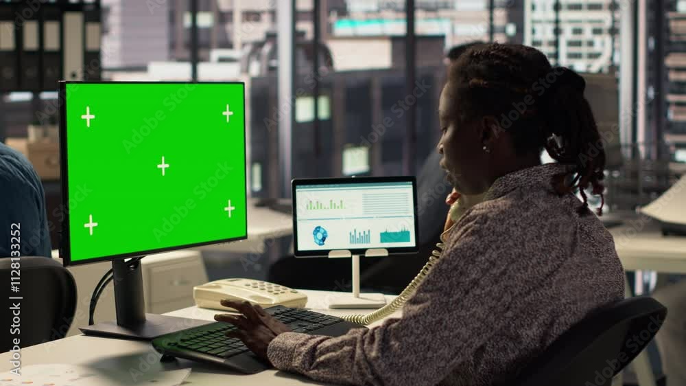 African American specialist looks at isolated mockup on computer, analyzing company data for strategic planning and enterprise goals. Resource allocation and effective business operations. Camera A. African American specialist looks at isolated mockup on computer, analyzing company data for strategic planning and enterprise goals. Resource allocation and effective business operations. Camera A.